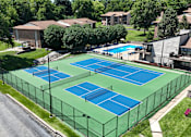 Thumbnail 29 of 35 - Tennis and pickleball courts surrounded by a fence.