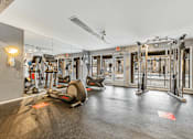 Thumbnail 25 of 35 - A gym with a variety of equipment including treadmills, stationary bikes, and weight machines.