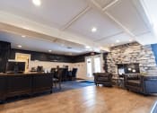 Thumbnail 11 of 17 - a lobby with a stone fireplace and a desk with chairs