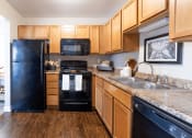 Thumbnail 5 of 17 - a kitchen with black appliances and wooden cabinets