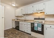 Thumbnail 2 of 14 - a kitchen with white cabinets and a stove and a sink