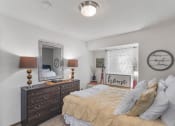 Thumbnail 7 of 22 - a bedroom with a bed and dresser