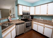 Thumbnail 12 of 34 - a kitchen with stainless steel appliances and white cabinets