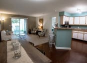 Thumbnail 13 of 34 - a living room with a kitchen and a table