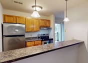 Thumbnail 1 of 19 - A kitchen with a granite countertop and wooden cabinets.