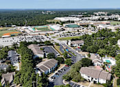 Thumbnail 26 of 26 - A bird's eye view of a residential area with houses, a school, and a football field.