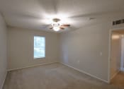 Thumbnail 13 of 22 - an empty living room with a ceiling fan and a window