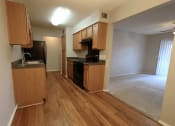 Thumbnail 10 of 22 - an empty kitchen and living room with wood flooring and