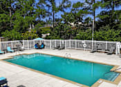 Thumbnail 19 of 26 - A small pool surrounded by a fence and trees.