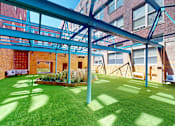 Thumbnail 25 of 30 - A green lawn with a blue metal frame structure above it.