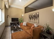 Thumbnail 1 of 30 - A living room with a brown couch and a black coffee table.