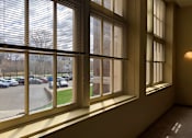Thumbnail 9 of 30 - A view of a parking lot through a window with blinds.