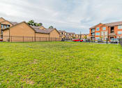 Thumbnail 21 of 22 - grassy dog park in front of apartment buildings