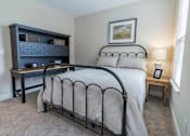 Thumbnail 12 of 22 - A bedroom with a bed, nightstand, and a dresser.