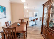 Thumbnail 6 of 22 - A dining room with a wooden table and chairs.