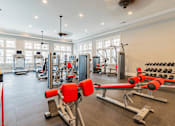 Thumbnail 16 of 22 - A gym with a variety of equipment including weights and machines.