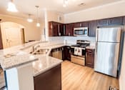 Thumbnail 2 of 22 - apartment kitchen with a granite counter top and stainless steel appliances