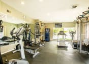 Thumbnail 5 of 14 - a gym with cardio equipment and a window