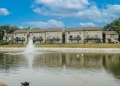 Thumbnail 13 of 14 - a duck swimming in a pond in front of an apartment building