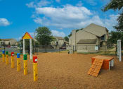 Thumbnail 9 of 14 - a playground with a picnic table in the foreground and houses in the background