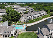 Thumbnail 29 of 31 - A large building complex with a pool and a fountain.