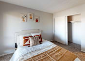 Thumbnail 11 of 31 - A bedroom with a bed, pillows, and a carpet.