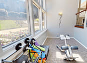 Thumbnail 15 of 31 - A gym with a variety of equipment including dumbbells, a bench, and resistance bands.