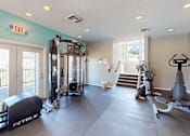 Thumbnail 14 of 31 - A gym with a variety of equipment including treadmills, weights, and a rowing machine.