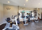 Thumbnail 17 of 31 - A gym with a row of exercise machines and a motivational wall.
