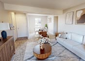 Thumbnail 3 of 31 - A living room with a white couch, a wooden coffee table, and a rug.