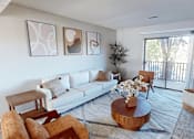 Thumbnail 1 of 31 - A living room with a white couch, a coffee table, and three abstract paintings on the wall.