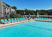Thumbnail 20 of 31 - A swimming pool with blue water and lounge chairs.