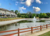 Thumbnail 12 of 14 - a pond with ducks and a fountain in front of a building