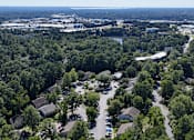 Thumbnail 13 of 16 - A bird's eye view of a residential area surrounded by trees.