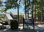 Thumbnail 15 of 16 - A sign for West Winds Townhomes is in front of a building.