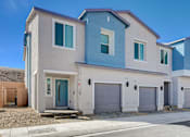 Thumbnail 1 of 93 - A modern two-story house with a blue door and garage doors.at Copper Creek Apartments, Las Vegas