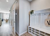 Thumbnail 3 of 93 - A hallway with a white bench and a bag hanging on it.at Copper Creek Apartments, Nevada