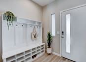 Thumbnail 2 of 93 - A white entryway with a coat rack and a potted plant.at Copper Creek Apartments, Las Vegas Nevada