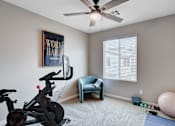 Thumbnail 39 of 93 - A room with a stationary bike, a chair, and a ball.at Copper Creek Apartments, Las Vegas, 89123