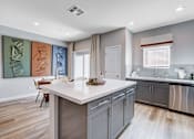 Thumbnail 47 of 93 - A modern kitchen with a white island and stainless steel appliances.at Copper Creek Apartments, Las Vegas