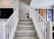 Thumbnail 71 of 93 - A staircase with a grey carpet and white railings.at Copper Creek Apartments, Las Vegas, NV 89123 
