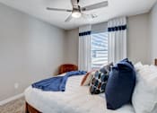 Thumbnail 91 of 93 - A bedroom with a bed, pillows, and a ceiling fan.at Copper Creek Apartments, Nevada, 89123