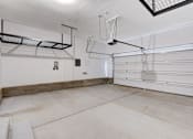 Thumbnail 85 of 93 - A spacious garage with a white floor and a ceiling fan.at Copper Creek Apartments, Las Vegas, NV 89123