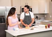 Thumbnail 4 of 93 - A man and a woman are cooking together in a kitchen.at Copper Creek Apartments, Las Vegas Nevada