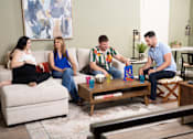Thumbnail 8 of 93 - A group of people are sitting on a couch in a living room.at Copper Creek Apartments, Las Vegas, NV 89123