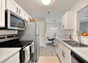 Thumbnail 2 of 39 - A kitchen with white cabinets and a black stove top.