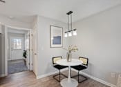 Thumbnail 4 of 39 - A dining room with a white table and chairs.