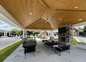Thumbnail 20 of 39 - A patio with a table and chairs and a fireplace.
