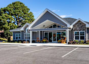 Thumbnail 26 of 39 - A large building with a parking lot in front.