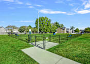 Thumbnail 34 of 39 - A park with a fence and a sign on a pole.